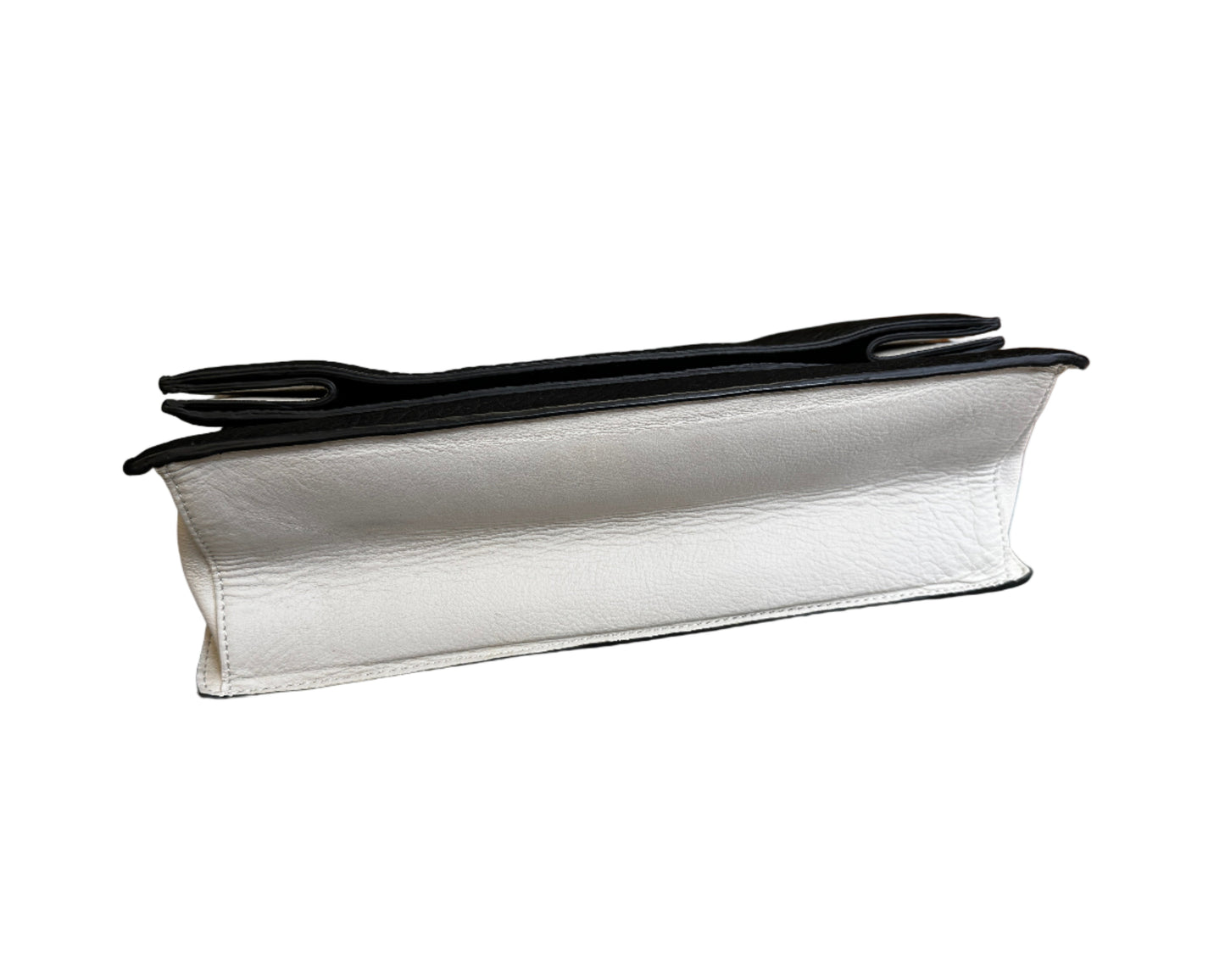 White leather clutch with black interior on a gray chair