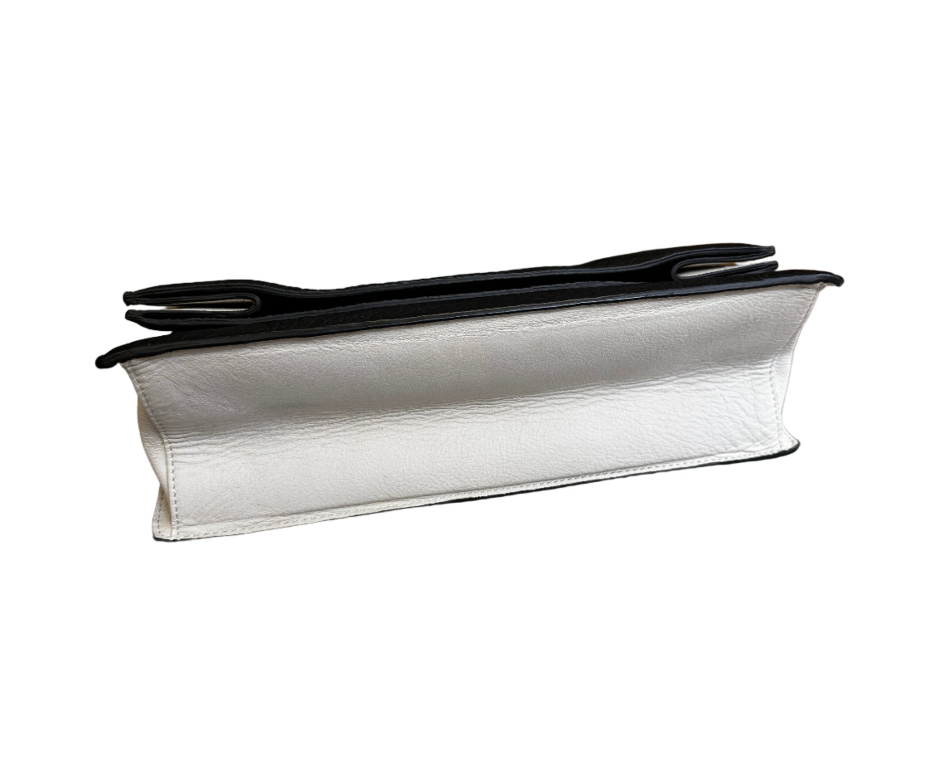 White leather clutch with black interior on a gray chair
