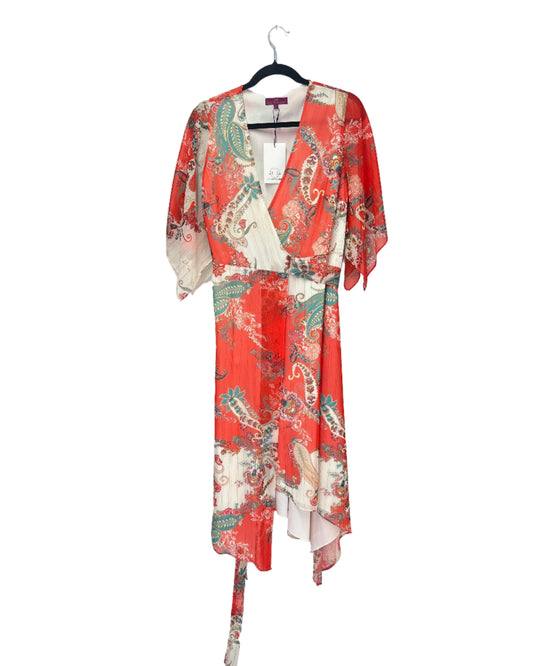 Red floral kimono hanging on a white wall next to a brick wall.