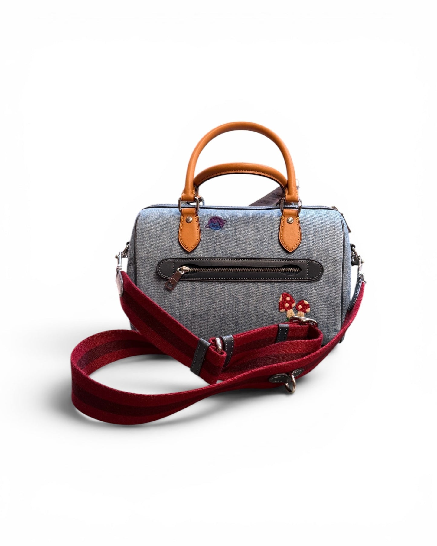 Gray handbag with brown handles and a red strap on a white background
