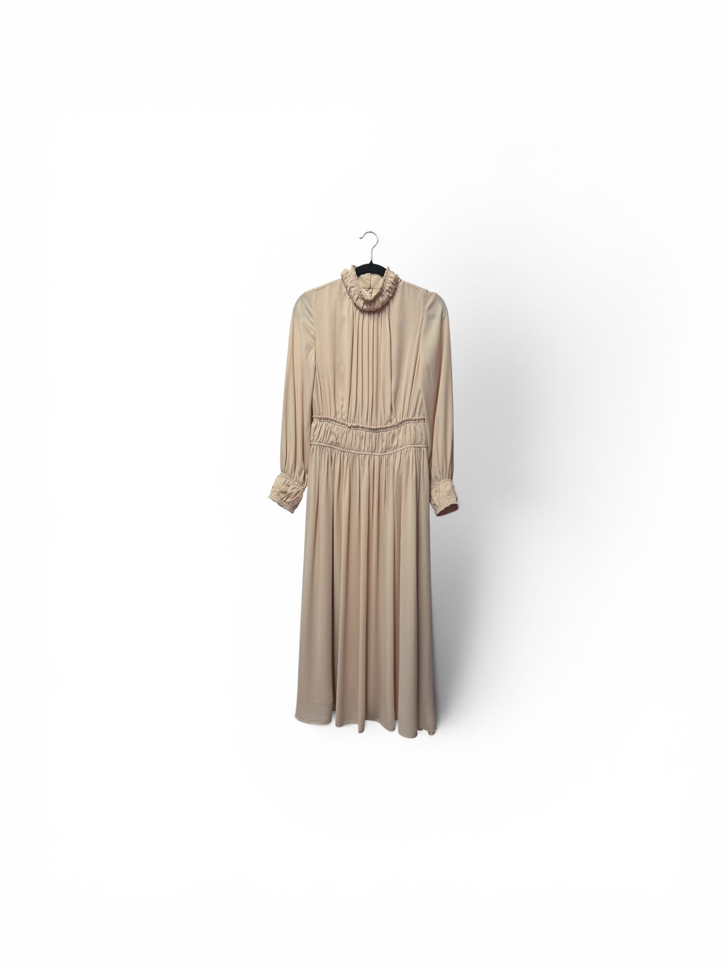 Beige dress on a hanger against a white background